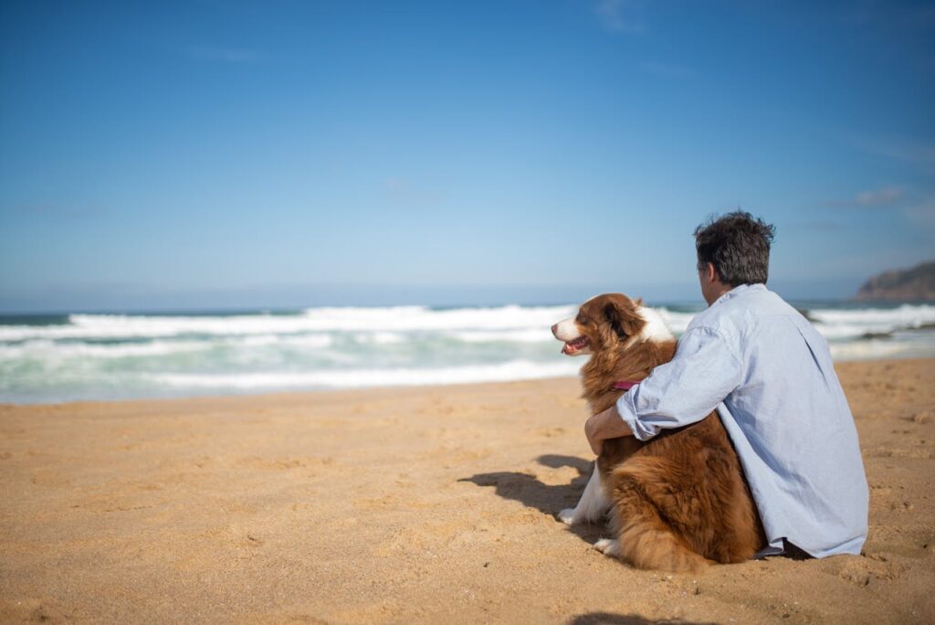 man with dog on the beach